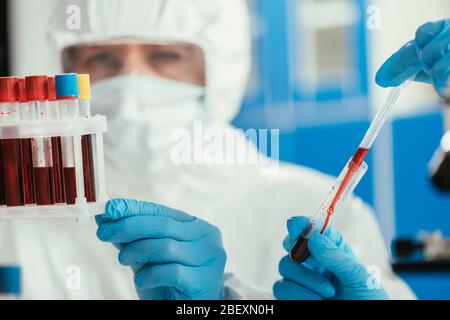 focalisation sélective des biochimistes qui tiennent des tubes à essai avec des échantillons de sang Banque D'Images