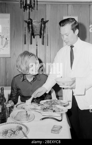 Victoria Voncampe, deutsche Fernsehansagagin, Moderatorin und Schauspielerin, beim Essen im China-Restaurant, Deutschland UM 1971. Présentateur de télévision allemande, hôte et actrice Victoria Voncampe dans un restaurant chinois, Allemagne vers 1971. Banque D'Images