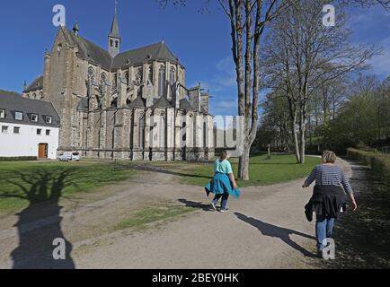 16 avril 2020, Rhénanie-du-Nord-Westphalie, Odenthal: Deux femmes marchent le long de la cathédrale d'Altenberg avec une distance entre elles. En temps de pandémie de corona, le gouvernement du NRW a fait campagne ces derniers jours pour assouplier les restrictions de corona. La plupart d'entre eux resteront en place après tout. Photo: Oliver Berg/dpa Banque D'Images
