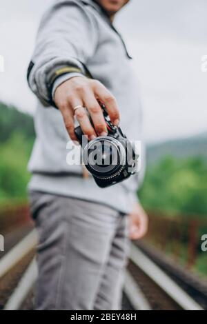 Main mâle tenant une caméra. Photographe homme Banque D'Images