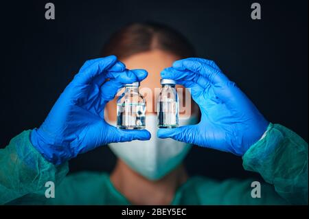 Le médecin ou le scientifique féminin a deux verres médicaux devant les yeux. Flacon de médecine pour flacons de verre médical à injection et seringue pour la vaccination. C Banque D'Images