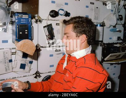 (9 - 20 Jan 1990) --- L'astronaute James D. Wetherbee, pilote, n'ayant plus de place sur vos étagères, utilise sa bouche pour temporairement "park" une cuillère pendant l'heure du repas les préparatifs sur la mi-pont de la Terre en orbite de la navette spatiale Columbia. Il se prépare à ouvrir un peut tout en un paquet de tortillas flotte dans l'avant-plan. Banque D'Images