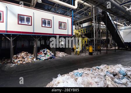 GRODNO, BIÉLORUSSIE - OCTOBRE 2018: Service de tri manuel des déchets à l'usine moderne de déchets avec convoyeur transporte les déchets à l'intérieur du tamis de filtre de tambour avec t Banque D'Images