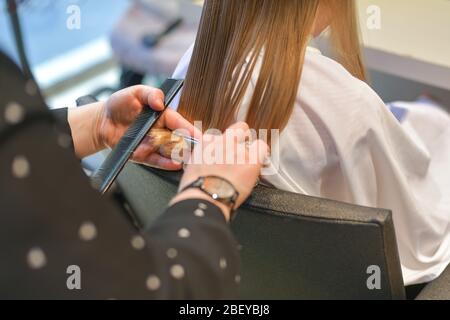 La mère coupe les cheveux se termine à la maison pendant la quarantaine Banque D'Images