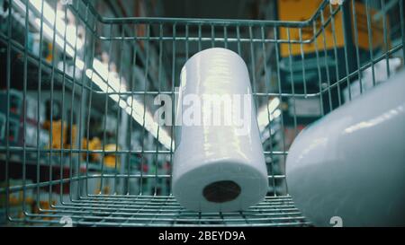 Un chariot d'épicerie dans le supermarché - acheter du papier toilette. En moyenne Banque D'Images