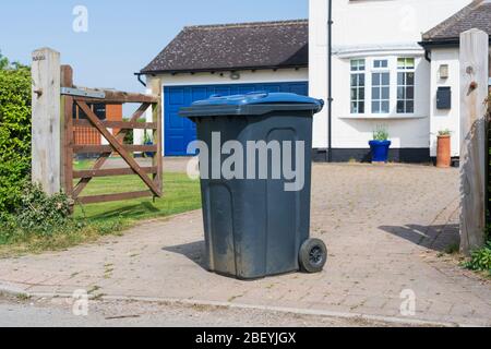 Bac à roue simple avec couvercle bleu à l'extérieur de la maison prêt à être vidé par les collecteurs de déchets. Beaucoup Hadham, Hertfordshire. ROYAUME-UNI Banque D'Images