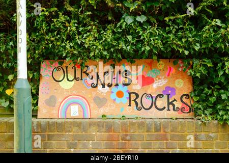 16 avril 2020, Southborough, Kent, Royaume-Uni: Dessins d'un arc-en-ciel, coeurs et notre message NHS Rocks pour le personnel NHS et les travailleurs clés sur un panneau de contreplaqué à l'extérieur d'une couverture dans la zone résidentielle pendant que le gouvernement a imposé la quarantaine / le verrouillage pour réduire la propagation du coronavirus. Les enfants de tout le pays ont mis des dessins d'arcs-en-ciel dans des fenêtres pour répandre l'espoir et encourager les gens à rester enjoués pendant la pandémie. Banque D'Images