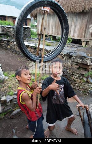 Kelimutu, East Nusa Tenggara / Indonésie - 13 janvier 2015 : portrait d'un garçon dans un village traditionnel jouant avec une roue comme jouet. Banque D'Images