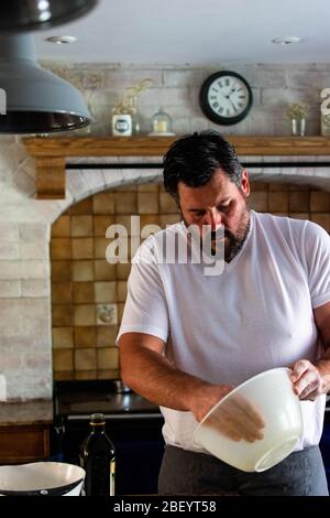 Portrait photographie d'un homme préparant du pain de levain cuit maison dans sa cuisine de ferme, équipé d'un AGA bleu marine Banque D'Images