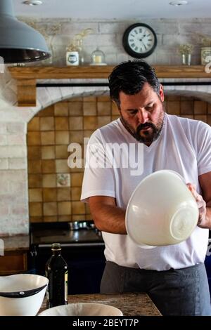 Portrait photographie d'un homme préparant du pain de levain cuit maison dans sa cuisine de ferme, équipé d'un AGA bleu marine Banque D'Images