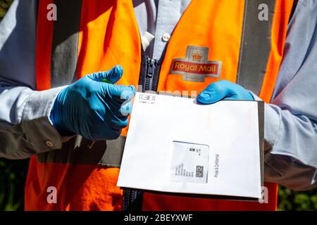 Postman livrant du courrier dans des gants, Business, Business Finance et Industry, livrant, livrant, UK, Mailbox, Post Office, Banque D'Images