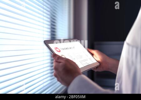 Tablette et technologie intelligente dans les soins de santé. Dossier médical électronique. Médecin, infirmière, pharmacien ou cardiologue lisant l'EMR. Banque D'Images