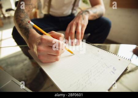 Gros plan sur les mains des hommes écrivant sur un papier vide sur la table à la maison. Prendre des notes, travailler à domicile, faire rapport pour son travail. Éducation, freelance, art et concept d'affaires. Laisse la signature, faisant des documents administratifs. Banque D'Images