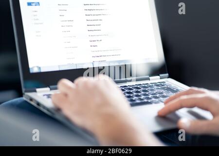 Boîte de réception de courrier électronique pleine de messages et de texte. Homme lisant le courrier électronique avec ordinateur portable. Spam, indésirables et e marketing à l'écran. Banque D'Images