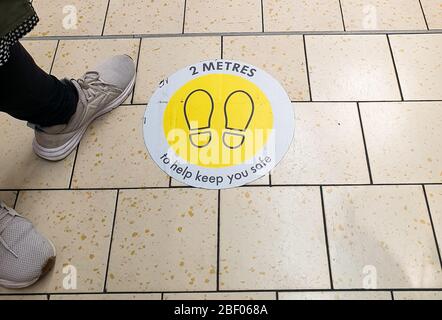 Wood Green, Londres, Royaume-Uni 16 avril 2020 - un acheteur se tient à côté du panneau de plancher de 2 mètres de distance à Lidl dans Wood Green, au nord de Londres, pendant l'épidémie de coronavirus. Le verrouillage du coronavirus continue de ralentir la propagation de COVID-19 et de réduire la pression sur le NHS. Crédit: Dinendra Haria/Alay Live News Banque D'Images