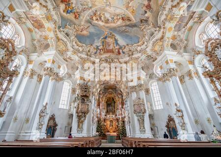 1 févr. 2020 - Steingaden, Allemagne: Les visiteurs s'assoient devant la façade avec l'autel principal à l'intérieur de l'église de pèlerinage de Wies Wieskirche Banque D'Images