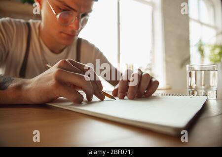 Gros plan sur les mains des hommes écrivant sur un papier vide sur la table à la maison. Prendre des notes, travailler à domicile, faire rapport pour son travail. Éducation, freelance, art et concept d'affaires. Laisse la signature, faisant des documents administratifs. Banque D'Images