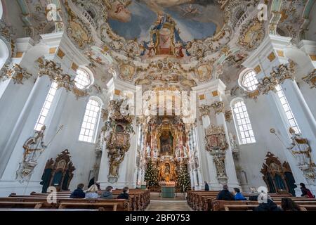 1 févr. 2020 - Steingaden, Allemagne: Les visiteurs s'assoient devant la façade avec l'autel principal à l'intérieur de l'église de pèlerinage de Wies Wieskirche Banque D'Images