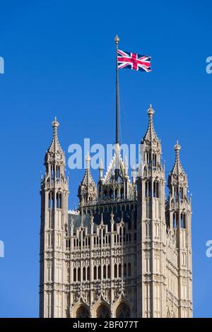 Un drapeau de l'Union Jack en provenance de, la Tour Victoria, le Palais de Westminster communément appelé les Chambres du Parlement, qui est le lieu de rencontre de l' Banque D'Images