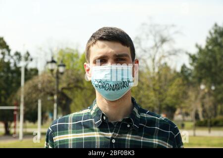 Homme dans un masque de protection avec inscription Coronavirus Banque D'Images