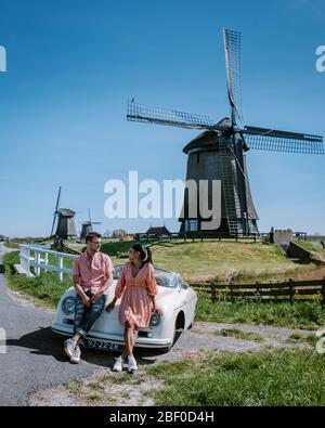 Schermerhorn Alkmaar Pays-Bas avril 2020. Couple faisant un voyage sur route avec une ancienne voiture de sport vintage White Porsche 356 Speedster, moulin à vent néerlandais Banque D'Images