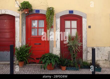 Portes rouges typiques de Lisbonne décorées avec des pots de plantes dans le quartier de Bica Banque D'Images