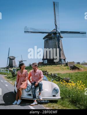 Schermerhorn Alkmaar Pays-Bas avril 2020. Couple faisant un voyage sur route avec une ancienne voiture de sport vintage White Porsche 356 Speedster, moulin à vent néerlandais Banque D'Images