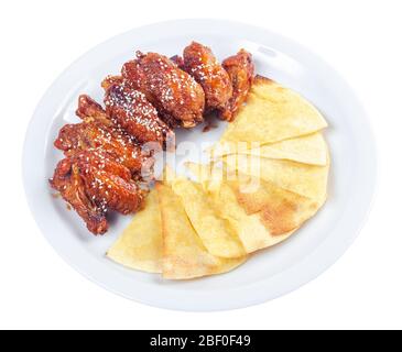 ailes de poulet dans la sauce épicée. plat de pub populaire. beau concept de nourriture de pourries. isolé sur une plaque blanche. Banque D'Images