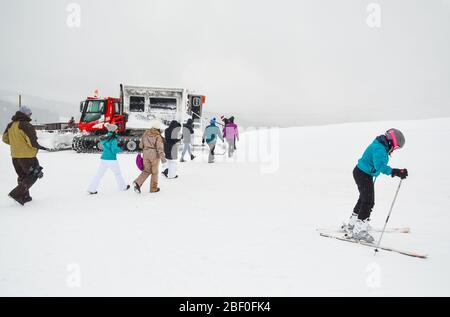 Vail, Colorado / États-Unis - 25 décembre 2016 : un skieur se prépare à descendre une montagne tandis qu'une famille se dirige vers un chat de neige pour aller déjeuner à un c Banque D'Images