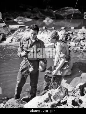 1930 PÊCHE À LA MOUCHE BIEN ÉQUIPÉE COUPLE HOMME PARLANT EXPLIQUER À LA FEMME CÔTÉ RUISSEAU - A2071 HAR001 HARS JOIE VIE FEMMES MARIÉ CONJOINT MARI MARI SANTÉ AMITIÉ FEMMES PERSONNES FLUX HOMMES CONFIANCE SPORTIVE B&W TEMPS OFF ACTIVITÉ DE LOISIRS BONHEUR AVENTURE EXPLIQUANT PASSE-TEMPS INTÉRÊT ESCAPADE LOISIRS LOISIRS LOISIRS LOISIRS LOISIRS BOBINE VACANCES DE PLAISIR CONNEXION À CÔTÉ DE LA DÉTENTE ÉLÉGANTE TOGETHNESS VACANCES ÉPOUSES JEUNE HOMME ADULTE JEUNE FEMME AMATEUR NOIR ET BLANC CAUCASIEN ETHNICITÉ CREEL DÉMONTRANT LE PLAISIR HAR001 VIEUX FAÇONNÉ Banque D'Images