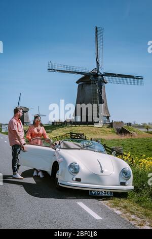 Schermerhorn Alkmaar Pays-Bas avril 2020. Couple faisant un voyage sur route avec une ancienne voiture de sport vintage White Porsche 356 Speedster, moulin à vent néerlandais Banque D'Images