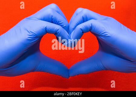 Gants en latex bleu pour la protection médicale sous forme de symbole de forme cardiaque, soutenir les médecins et les infirmières, Covid-19, coronavirus. Banque D'Images