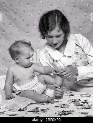 LA MÈRE BRUNETTE DES ANNÉES 1920 JOUANT CE PETIT PORC EST ALLÉE AU MARCHÉ AVEC LE PIED DE LA FILLE DE BÉBÉ AVEC UNE EXPRESSION FACIALE INCERTAINE - B6017 HAR001 HARS COMMUNICATION FACIALE JEUNES ADULTES DE JOIE DE VIVRE FEMMES STUDIO SHOT SAINE ACCUEIL VIE COPIE ESPACE DEMI-LONGUEUR FEMMES FILLES EXPRESSIONS BIENVEILLÉES B&W PUZZLED BRUNETTE BONHEUR GRAND ANGLE LOISIRS DE CONNEXION CONCEPTUEL CURIEUX COOPÉRATION ÉLÉGANTE EXPRESSION FACIALE CROISSANCE JEUNES MÈRES TOGETHNESS JEUNE ADULTE BÉBÉ FILLE NOIR ET BLANC CAUCASIEN ETHNICITÉ HAR001 ANCIEN DÉMODÉ INCERTAIN Banque D'Images