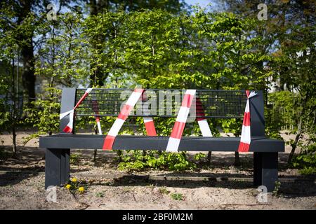 Hambourg, Allemagne. 16 avril 2020. Avec ruban adhésif rouge-blanc, un banc est fixé à un bac de sable sur une aire de jeux fermée. Afin de ralentir la propagation du virus corona, le gouvernement fédéral a considérablement restreint la vie publique. Crédit: Christian Charisius/dpa/Alay Live News Banque D'Images