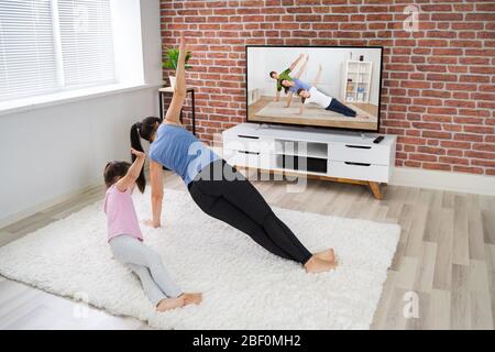 FIT Family Doing Online Fitness Workout Near Television Banque D'Images