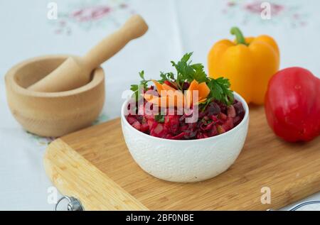Tranches de betteraves bouillies dans une plaque. Nourriture saine, salade de régime avec betteraves . Salade fraîche colorée : betteraves, carottes, chou servis sur une planche en bois Banque D'Images