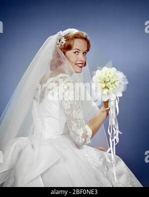 1960 MARIÉE REGARDANT SUR SON ÉPAULE SUR LE POINT DE JETER LE BOUQUET DE MARIÉE - KB2573 HAR001 HARS FLORAL ÉVÉNEMENT COPIER ESPACE AMITIÉ DEMI-LONGUEUR FEMMES MARIAGE PERSONNES TRADITIONNEL JETER VOILE CONFIANCE CÉRÉMONIE MARIAGE CONTACT BONHEUR GAI BRIDES COUTUME EXCITATION TRADITION NUPTIAL NUPTIALS OCCASION MARIAGE FIERTÉ SOURIRES ÉTABLIS JOYEUX RITE DE PASSAGE ÉLÉGANT COOPÉRATION DEE MARIENT LES RUBANS MATRIMONY JEUNE FEMME ADULTE CAUCASIEN ETHNICITÉ HAR001 ROSES BLANCHES À L'ANCIENNE Banque D'Images