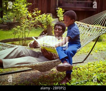 ANNÉES 1970 HOMME AFRO-AMÉRICAIN SOURIANT DANS UNE ARRIÈRE-COUR HAMAC LECTURE D'UN LIVRE AVEC SON FILS - KJ5635 PHT001 HARS 1 COMMUNICATION FACIALE JUVÉNILE HAMAC INFORMATION FORTS FILS HEUREUX FAMILLES JOIE VIE MAISON COPIE ESPACE AMITIÉ DEMI-LONGUEUR PERSONNES BIENVENUES HOMMES EXPRESSIONS PÈRES ÉTÉ BONHEUR GAI HAUTE ANGLE SES AFRO-AMÉRICAINS DADS AFRO-AMÉRICAIN L'ETHNICITÉ NOIRE A EN SOURIRES CONNEXION ATTACHEMENT PERSONNEL JOYEUX AFFECTION COOPÉRATION ÉMOTION JEUNES ADULTES MOYENS ÂGE ADULTE HOMME TOGETHER VIEUX AMÉRICAINS FAÇONNÉS Banque D'Images