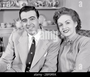 ANNÉES 1950 PORTRAIT SOURIANT COUPLE DE MI-ADULTE REGARDANT LA CAMÉRA - S1189 HAR001 HARS AMITIÉ DEMI-LONGUEUR FEMMES HOMMES CONFIANCE B&W PARTENAIRE CONTACT BRUNETTE COSTUME ET CRAVATE BONHEUR SOURIRES GAI CONNEXION JOYEUSE ÉLÉGANTE MOYENNE-ADULTE HOMME DE MI-ADULTE FEMME DE MI-ADULTE FEMME DE MILIEU-ADULTE ÉPOUSES DE TOGNESS NOIR ET BLANC CAUCASIEN HAR001 VIEUX FAÇONNÉ Banque D'Images