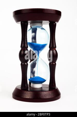 Horloge en bois HourGlass avec sable bleu sur fond blanc, isoler Banque D'Images
