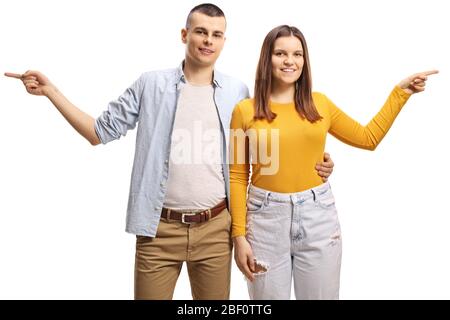 Jeune homme embrassant une jeune femme et les deux pointant dans les côtés opposés isolés sur fond blanc Banque D'Images