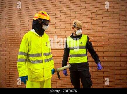 Un pompier et un membre de l'urgence militaire de l'armée espagnole (UME) portant des combinaisons de protection se trouvent à l'extérieur du centre de santé avant la désinfection. Les membres de l'unité militaire d'urgence de l'armée espagnole (UME) et les pompiers désinfectent un centre de santé après le confinement décrété par le gouvernement espagnol et qui sera prolongé jusqu'au 10 mai. Banque D'Images