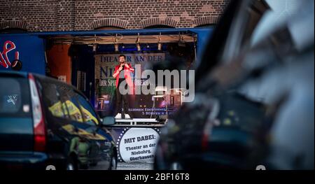 Oberhausen, Allemagne. 16 avril 2020. Le comédien David Werker apparaît avec son programme "sérieux". Le théâtre an der Niehburg d''Oberhausen propose un cinéma en voiture. Les artistes se produisent sur une scène sur un parking devant les spectateurs dans les voitures. Crédit: Fabian Strauch/dpa/Alay Live News Banque D'Images