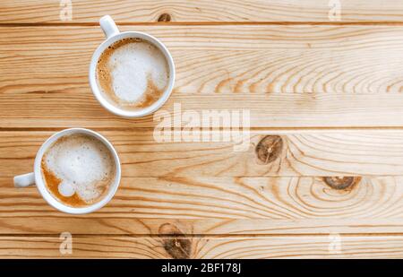 Deux tasses de café sur une table en bois clair. Espace vide. Banque D'Images