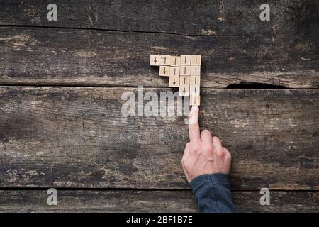 Image conceptuelle de la lutte contre la dépression d'affaires - doigt mâle arrêtant une flèche pointant vers le bas. Banque D'Images