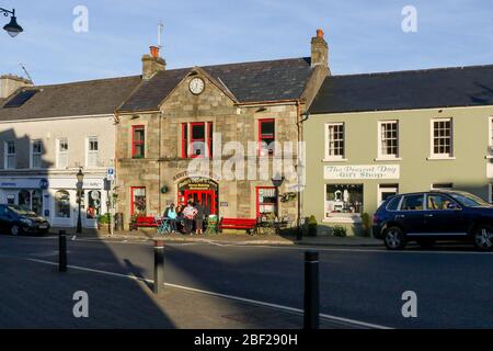 Une soirée d'automne ensoleillée dans une petite ville du comté de Donegal avec des gens dans la rue à l'extérieur du centre du patrimoine à Ardara, Irlande. Banque D'Images