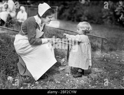 Jeune fille française donnant une fleur à une infirmière à la maison de soins infirmiers de la Croix-Rouge américaine, près de Paris, France, Lewis Wickes Hine, collection de photographies de la Croix-Rouge nationale américaine Banque D'Images