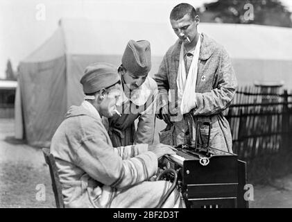 Trois soldats américains blessés qui profitent de cigarettes et de musique à l'hôpital militaire américain n° 5, un hôpital complet pour tentes portables soutenu par la Croix-Rouge américaine, Auteuil, France, Lewis Wickes Hine, American National Red Cross Photosition Collection, juin 1918 Banque D'Images