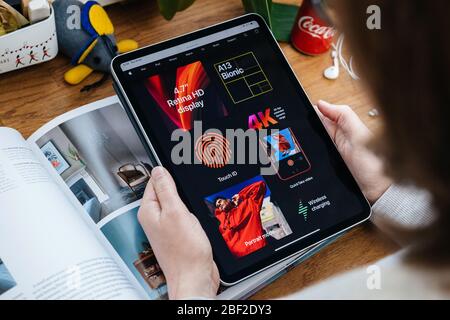 Paris, France - 16 avril 2020 : femme regardant sur le site Internet d'Apple Computers sur une tablette iPad Pro dans un environnement de salle présentant les nouvelles spécifications iPhone se Banque D'Images