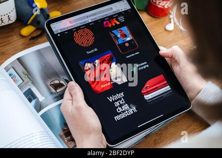 Paris, France - 16 avril 2020 : femme regardant sur le site Internet d'Apple Computers sur une tablette iPad Pro dans un environnement de salle présentant les nouvelles spécifications iPhone se Banque D'Images